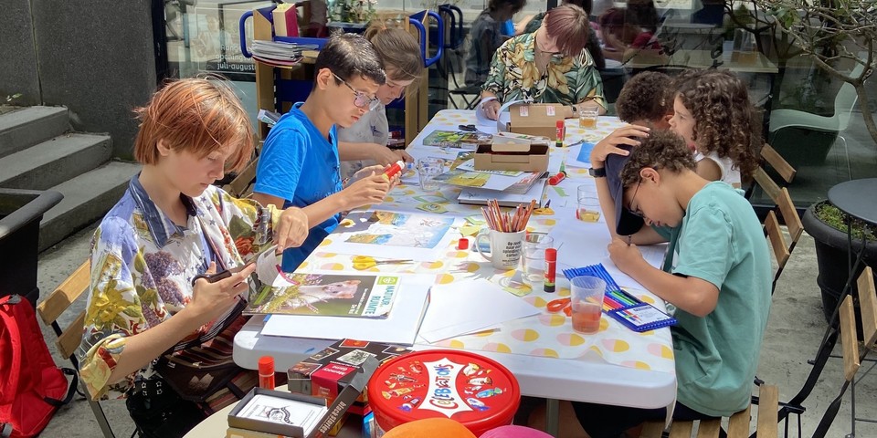 Knutselende kinderen rond een tafel op het terras van Bib park